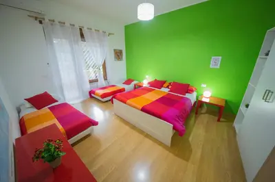 a green bedroom with two beds with colorful sheets at Da Paolo al Vaticano in Rome