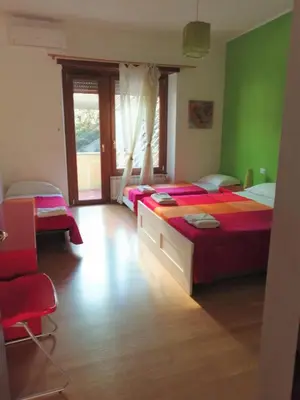 a bedroom with two beds with red sheets and a window at Da Paolo al Vaticano in Rome