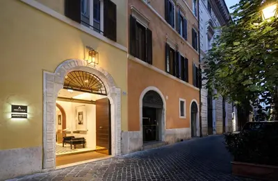 a building with an archway next to a street at Margutta 19 - Small Luxury Hotels of the World in Rome
