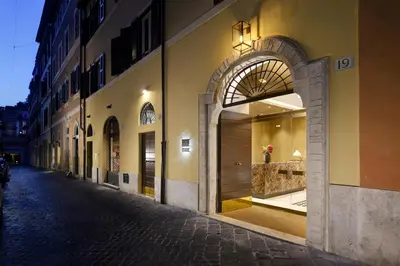 an empty street with an archway on a building at Margutta 19 - Small Luxury Hotels of the World in Rome