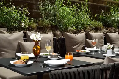a table with plates of food and glasses of wine at Margutta 19 - Small Luxury Hotels of the World in Rome