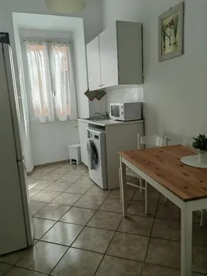 a kitchen with a table and a stove and a microwave at Roman Holidays in Rome