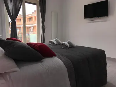 a bedroom with a bed with a television on the wall at Dunant House in Rome
