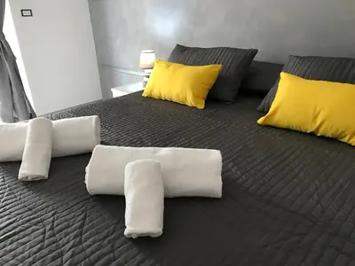 a bed with white towels and yellow pillows at Dunant House in Rome