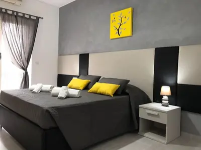 a bedroom with a bed with yellow pillows and a clock at Dunant House in Rome