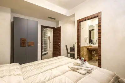 a woman laying on a bed in a bedroom at Rifugio degli Artisti Top B&B in Rome