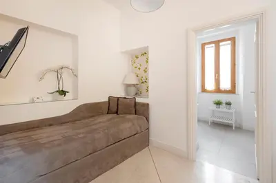 a living room with a brown couch and a window at i Fiori de' Mario Suites in Rome