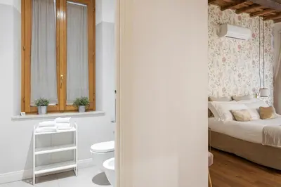 a white bathroom with a bed and a toilet at i Fiori de' Mario Suites in Rome