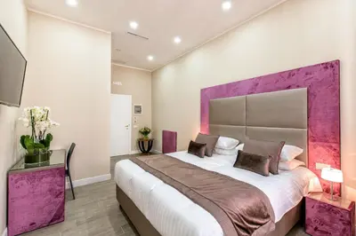 a bedroom with a large bed with a purple headboard at Bloom Apartment in Rome