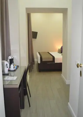 a small hotel room with a bed and a desk at Bloom Apartment in Rome