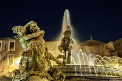 a fountain with two statues in front of a building at Bloom Apartment in Rome