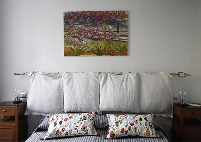 a bed with pillows and a painting on the wall at L'architetto in Rome