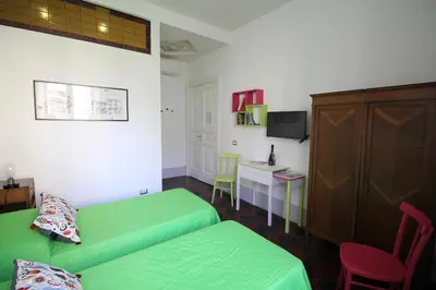 a bedroom with two green beds and a tv at L'architetto in Rome