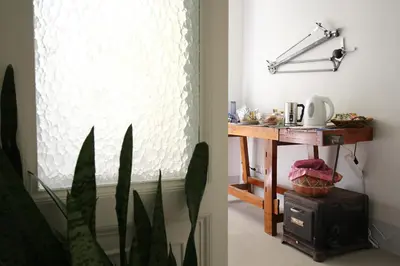 a room with a table and a window with a blind at L'architetto in Rome