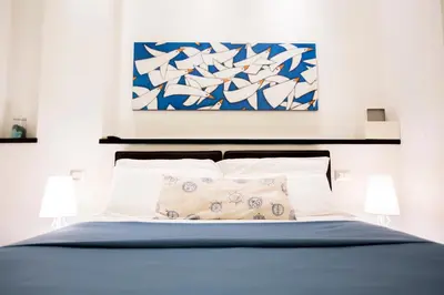 a bedroom with a bed with a painting above it at Bbqueen in Rome