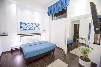 a bedroom with a blue bed and a mirror at Bbqueen in Rome