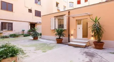 a yellow building with a wooden door on a street at Parioli House near Borghese-LUISS University in Rome