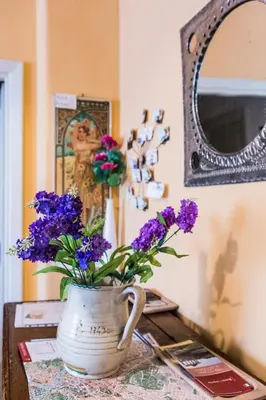 a vase filled with purple flowers sitting on a table at La Casetta Di Tiziana in Rome