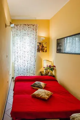 a bedroom with a red bed with two pillows at La Casetta Di Tiziana in Rome