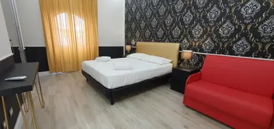a bedroom with a bed and a red couch at Rome Aparts in Rome