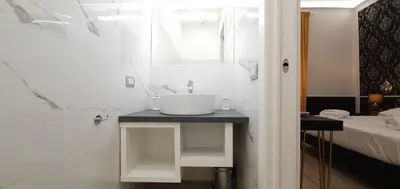 a white bathroom with a sink and a bed at Rome Aparts in Rome