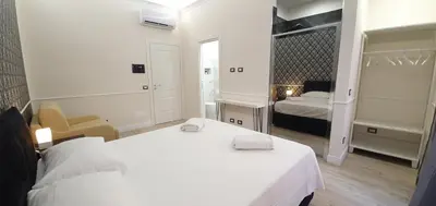 a white bedroom with a bed and a bed and a room with two beds at Rome Aparts in Rome