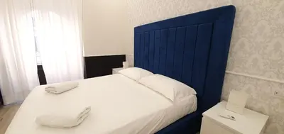 a bed with a blue headboard in a bedroom at Rome Aparts in Rome