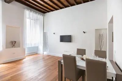 a dining room with a table and chairs and a television at Campo Marzio Boutique in Rome