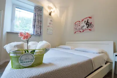 a small bedroom with a bed with a flower in a basket at Bed&BikeRome ROOMS in Rome
