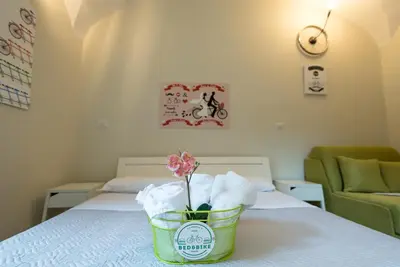 a hotel room with a flower in a basket on a bed at Bed&BikeRome ROOMS in Rome