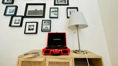 a table with a laptop on it with a lamp and pictures on the wall at Micol's Place, bright apt 2 rooms, 2 toilets, near metro, 80 mq in Rome