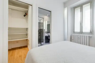 a bedroom with a white bed and a mirror at Micol's Place, bright apt 2 rooms, 2 toilets, near metro, 80 mq in Rome