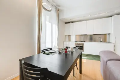 a kitchen and dining room with a black table at Micol's Place, bright apt 2 rooms, 2 toilets, near metro, 80 mq in Rome