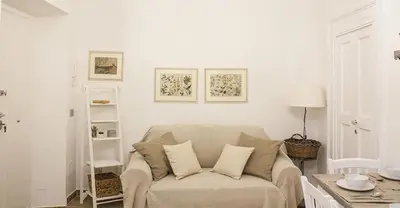 a white living room with a couch and a table at Splendid House In Trastevere in Rome