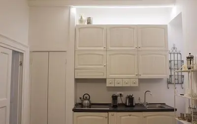 a kitchen with white cabinets and a sink at Splendid House In Trastevere in Rome