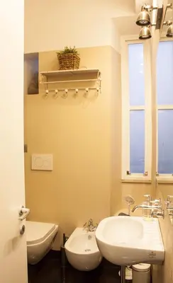 a bathroom with a sink and a toilet and a window at Splendid House In Trastevere in Rome
