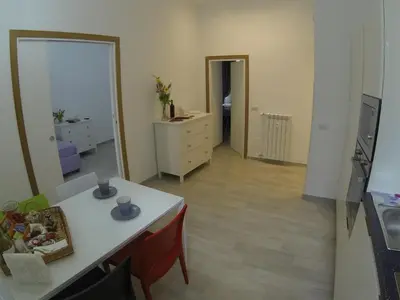 a living room with a white table and a dresser at Suite Luisa Roma in Rome