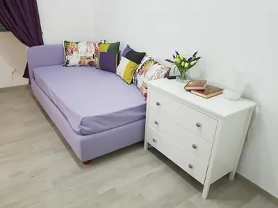 a purple couch next to a white dresser with a table at Suite Luisa Roma in Rome