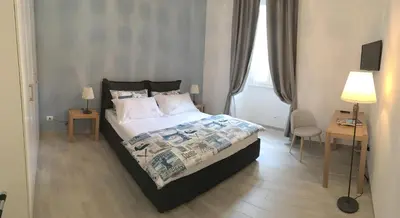 a bedroom with a bed and a desk and a lamp at Suite Luisa Roma in Rome