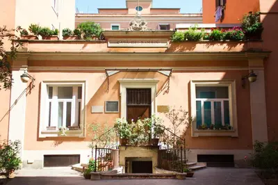 a building with potted plants on the front of it at TrastevereHome - Vespucci Rome Testaccio Home in Rome