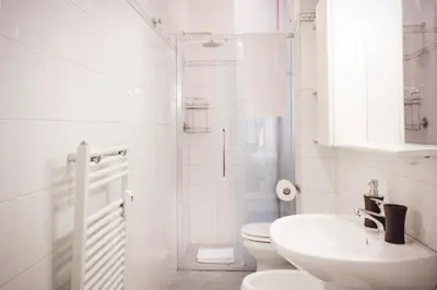 a white bathroom with a toilet and a sink at TrastevereHome - Vespucci Rome Testaccio Home in Rome