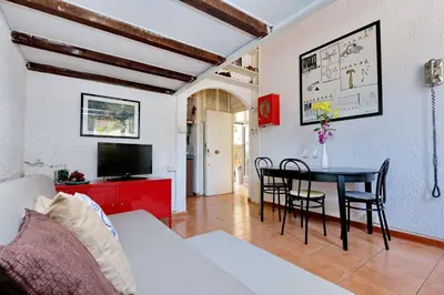 a living room with a table and chairs and a tv at Pretty Flat Trastevere in Rome