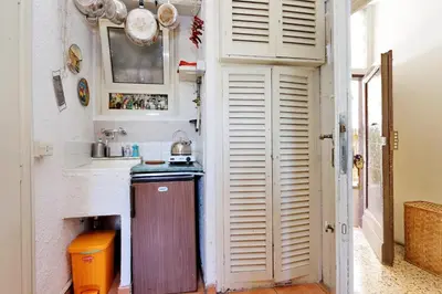 a small kitchen with white cabinets and a sink at Pretty Flat Trastevere in Rome