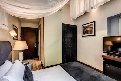 a bedroom with a bed and a flat screen tv at Hotel Giuggioli in Rome