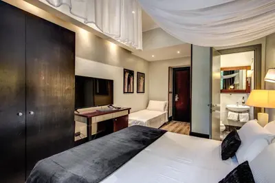 a bedroom with a large bed and a bathroom at Hotel Giuggioli in Rome