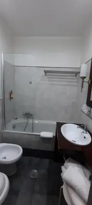 a bathroom with a toilet and a sink and a tub at Hotel Giuggioli in Rome
