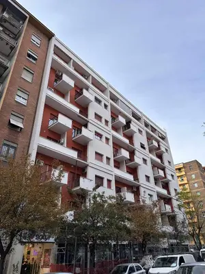 a large apartment building with cars parked in front of it at Rhome Away Marconi in Rome