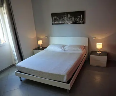 a bed in a bedroom with two lamps on tables at Rhome Away Marconi in Rome