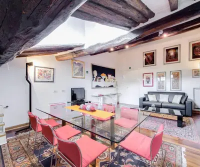a dining room with a glass table and pink chairs at Appartamento Piazza del parlamento 3 in Rome
