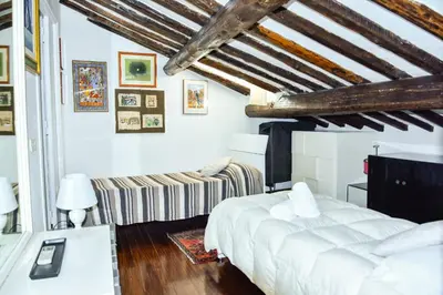a bedroom with a white bed and a couch at Appartamento Piazza del parlamento 3 in Rome
